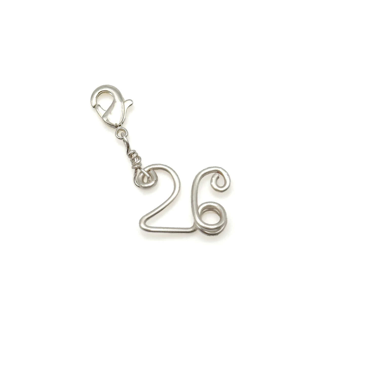 Silver number '26' charm on a white background