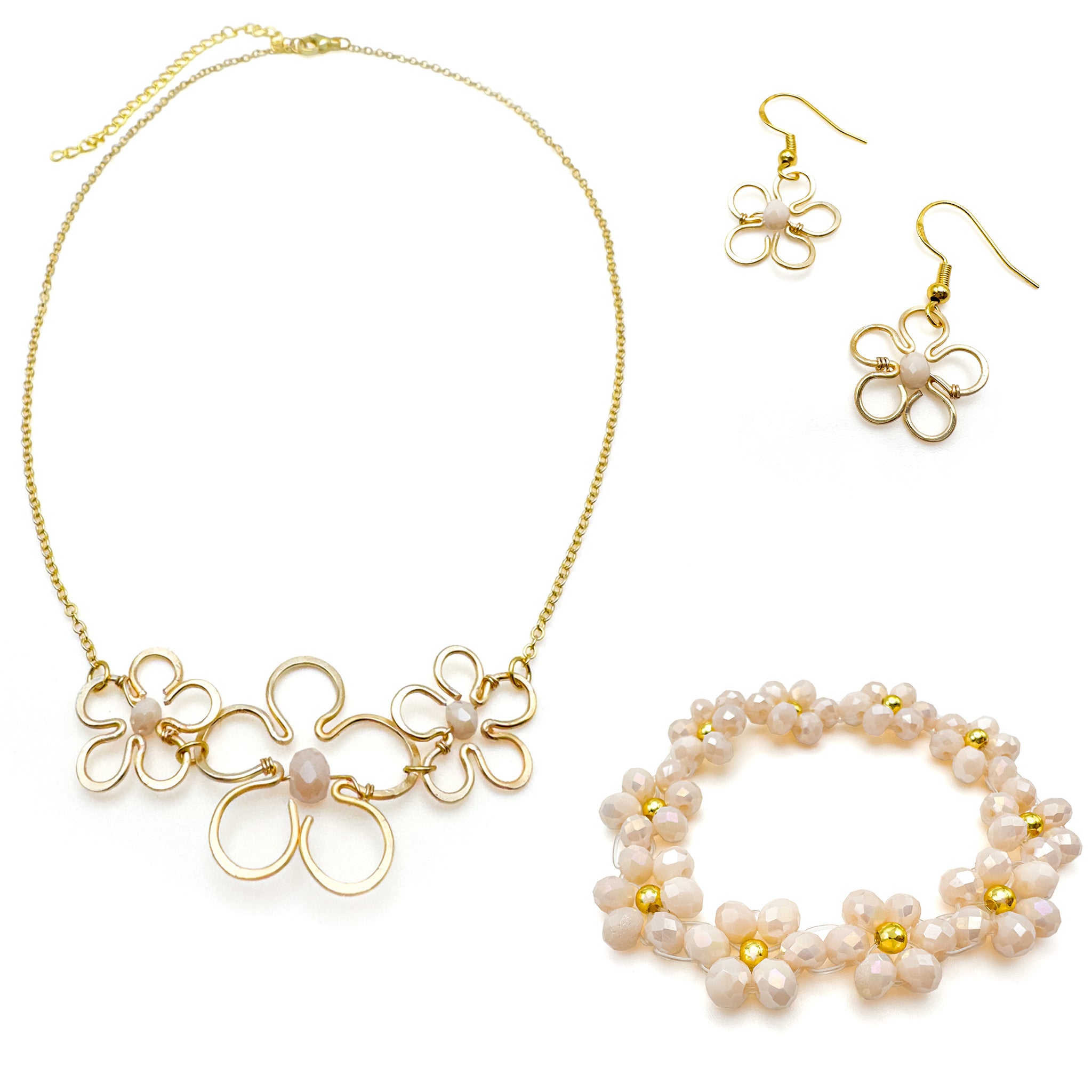 Gold jewelry set with floral dangle earrings, statement necklace, and peach beaded stretch bracelet