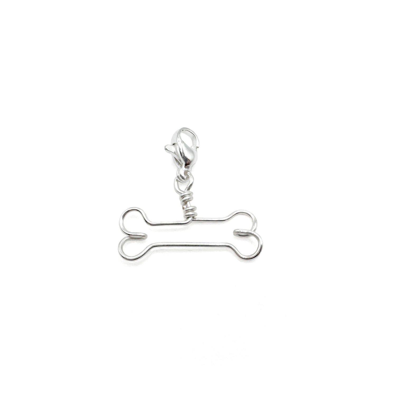 Silver bone-shaped charm on a white background