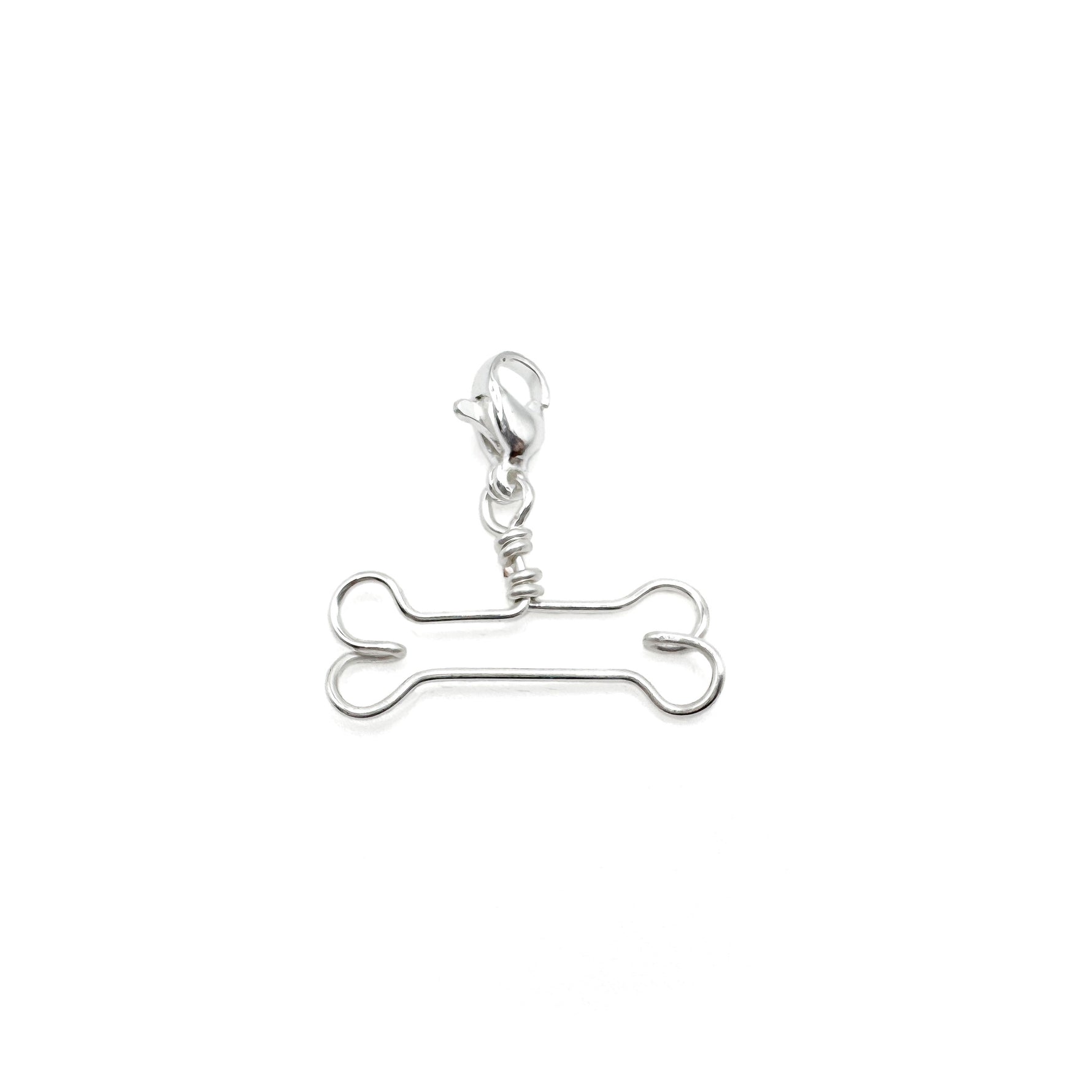 Silver bone-shaped charm on a white background