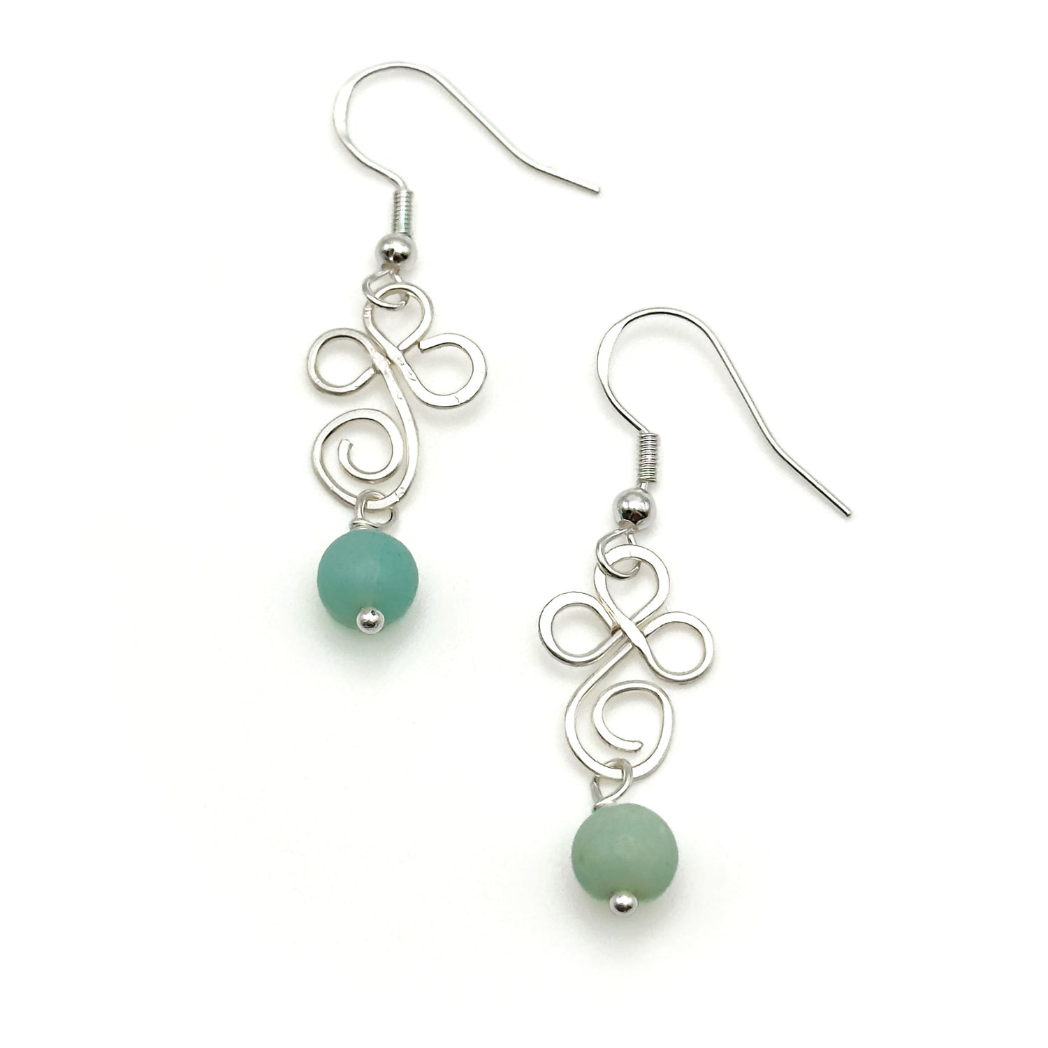 Silver earrings with turquoise beads on a white background