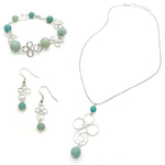 Jewelry set with necklace, bracelet, and earrings featuring turquoise beads on a white background