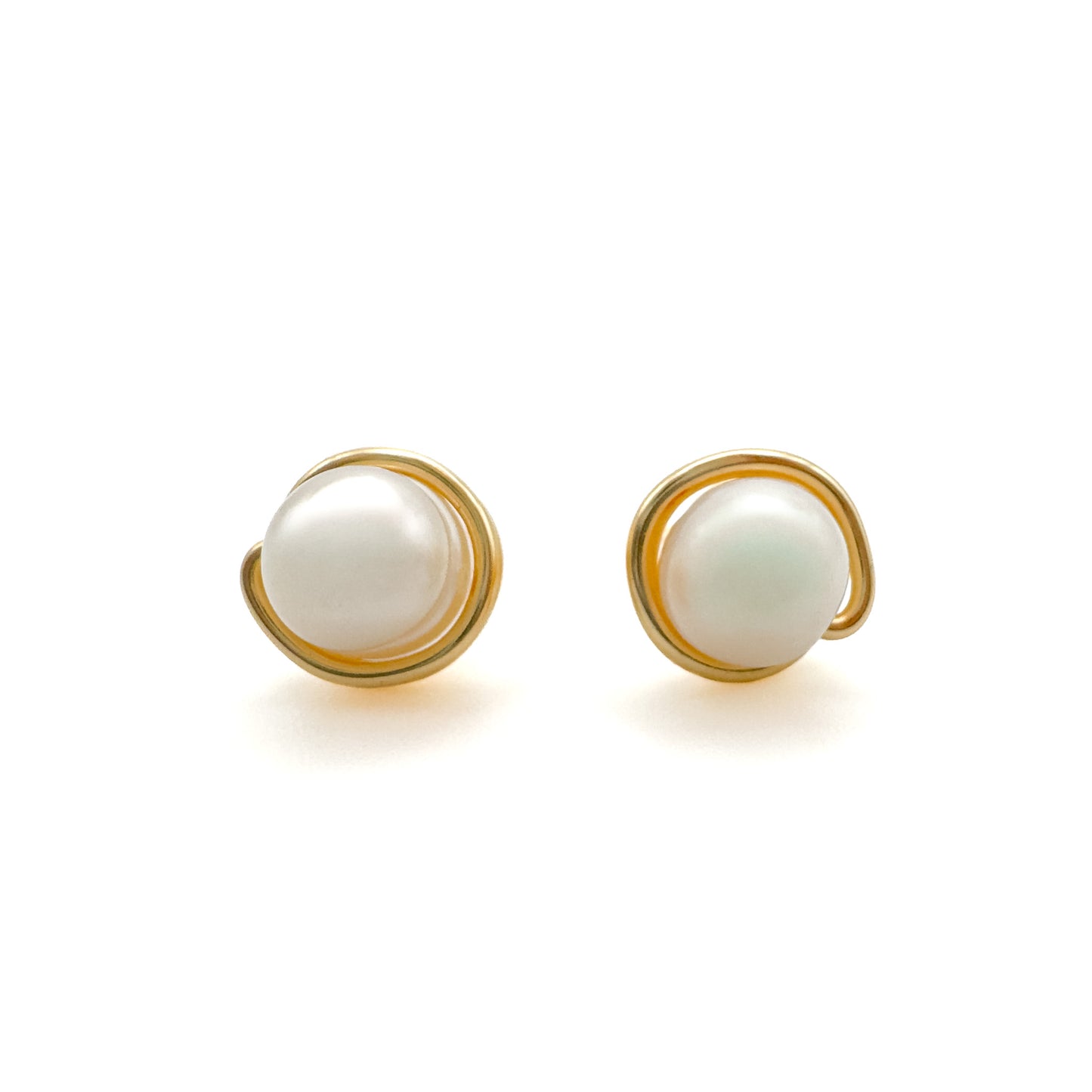 Pair of pearl earrings with gold frames on a white background