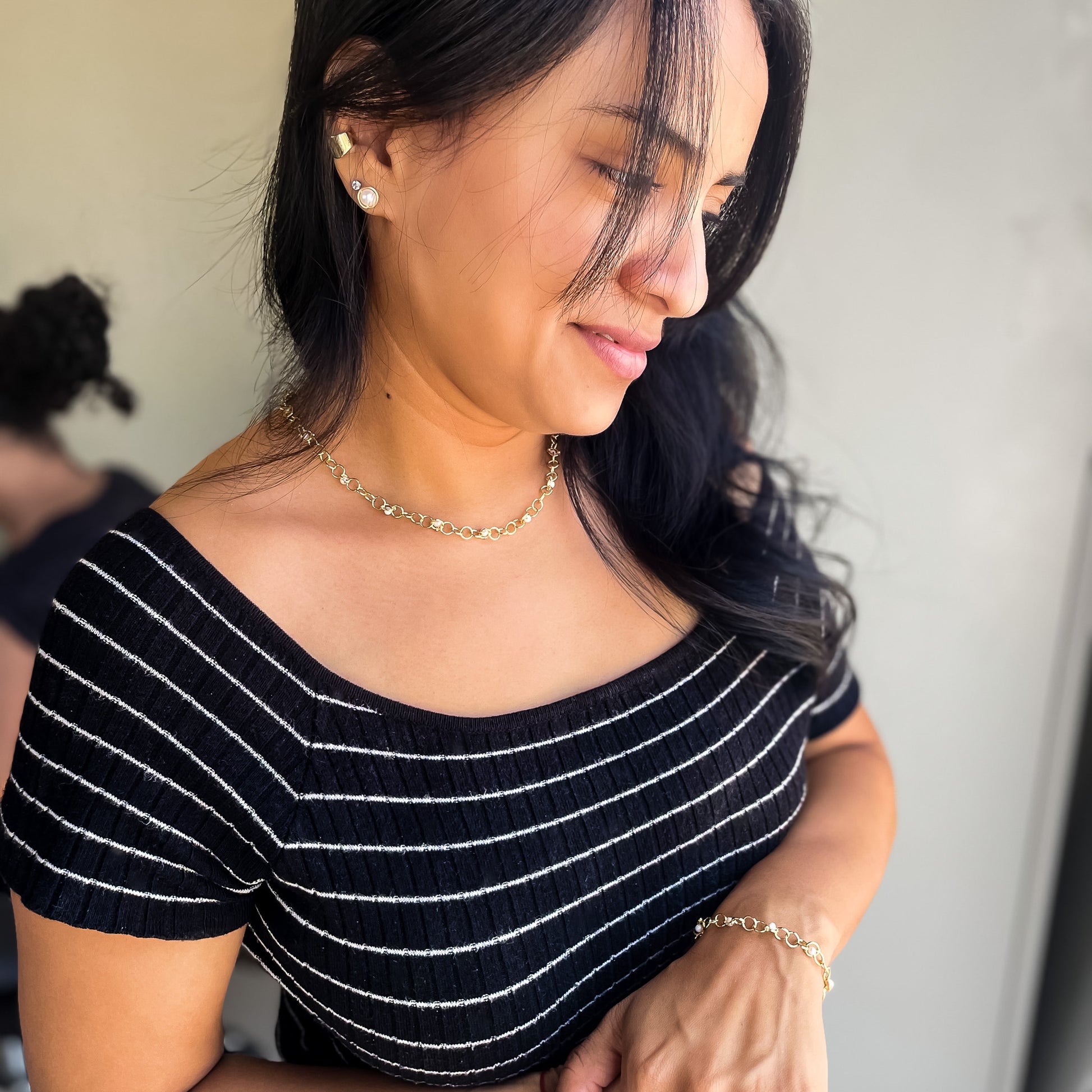 Woman wearing a black and white striped shirt with a neutral background