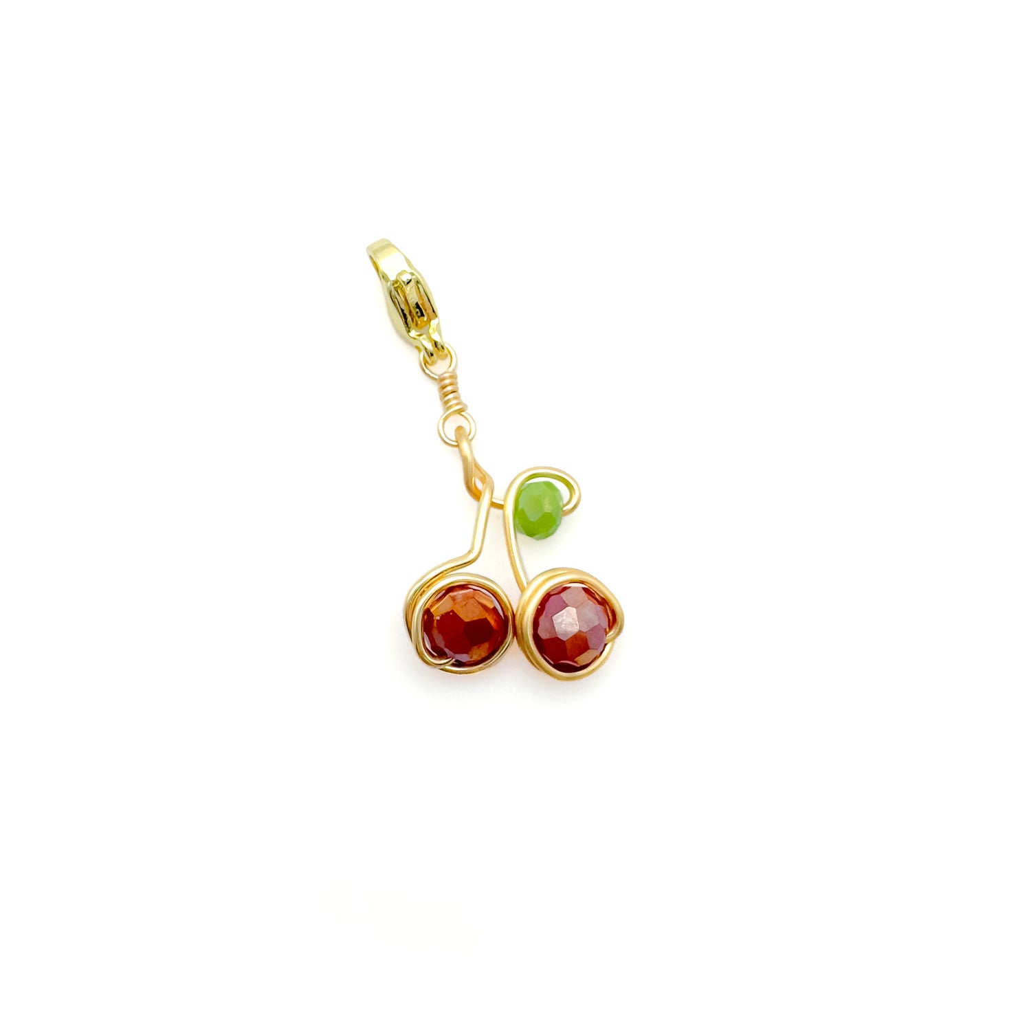 Gold charm shaped like cherries with red and green crystals