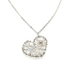 Close up of short silver necklace with intricate silver and pearl heart-shaped pendant