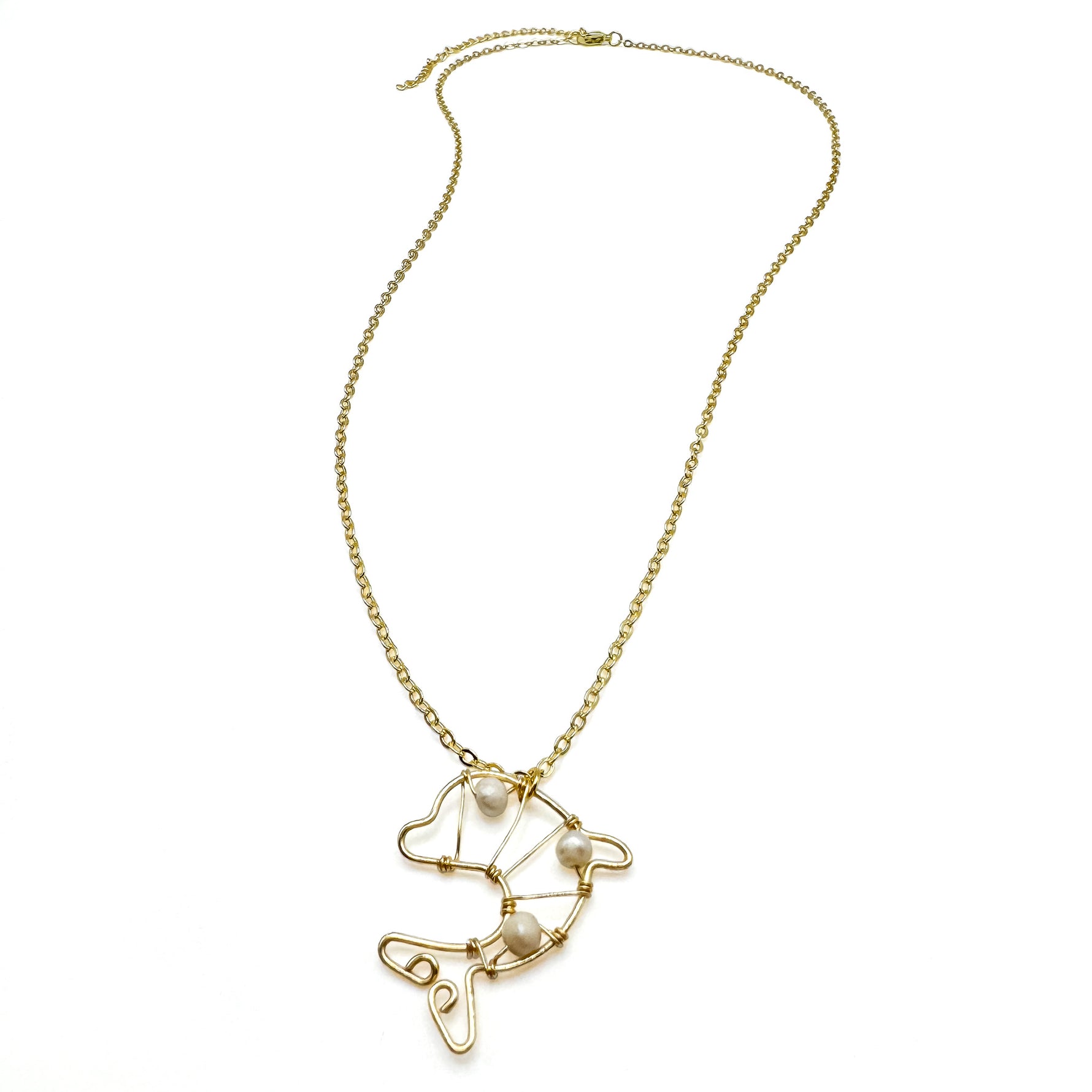 Long gold necklace with wire-wrapped gold and pearl dolphin pendant