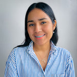 Woman modeling small mother of pearl dolphin earrings and long gold necklace with wire-wrapped gold and pearl dolphin pendant