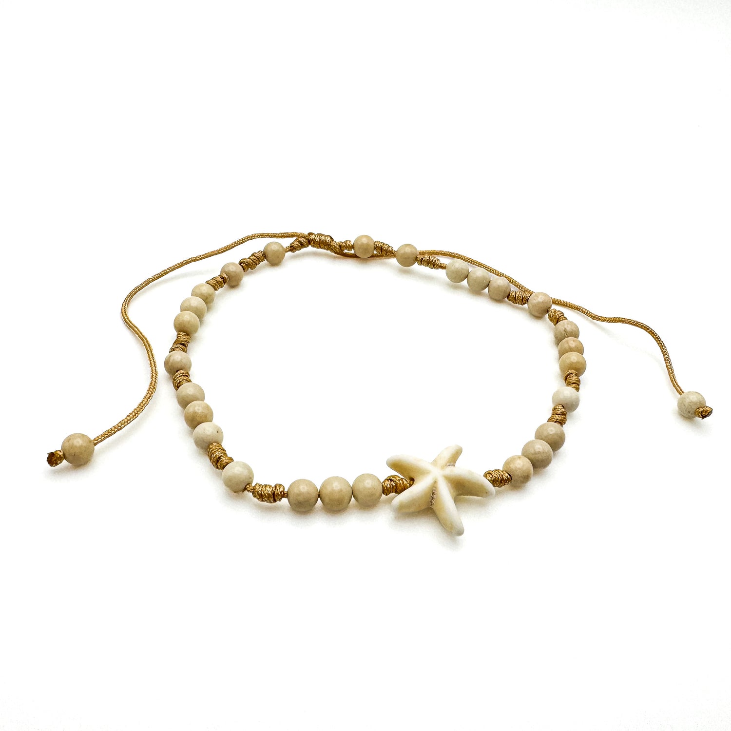 Tan adjustable sliding cord anklet with a single white starfish bead and white fossil jade beads