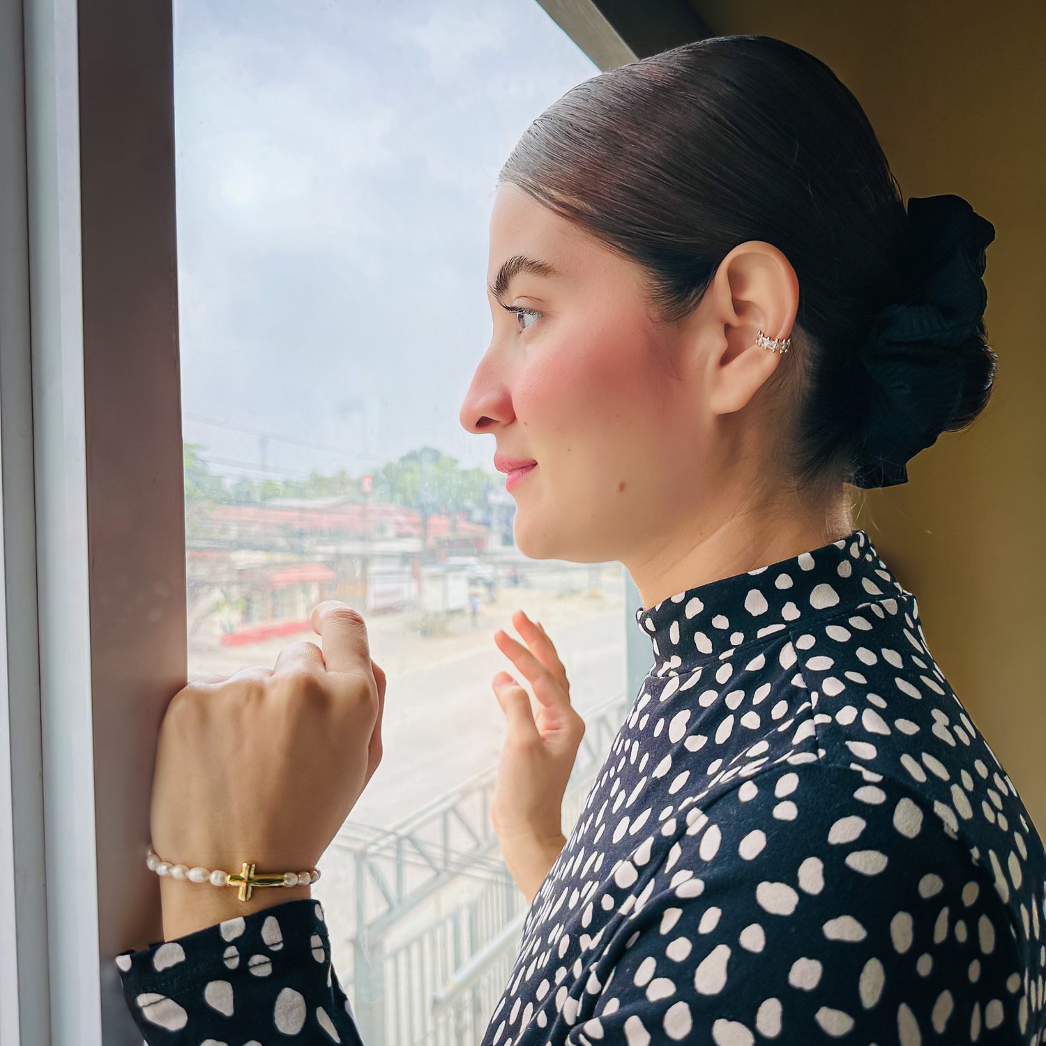 Woman modeling freshwater rice pearl stretch bracelet with gold sideways cross charm