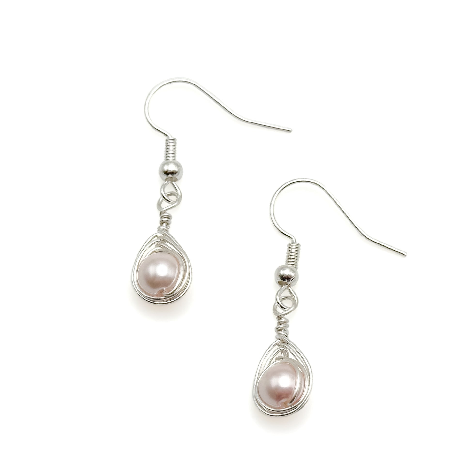 Silver earrings with pink pearls on a white background
