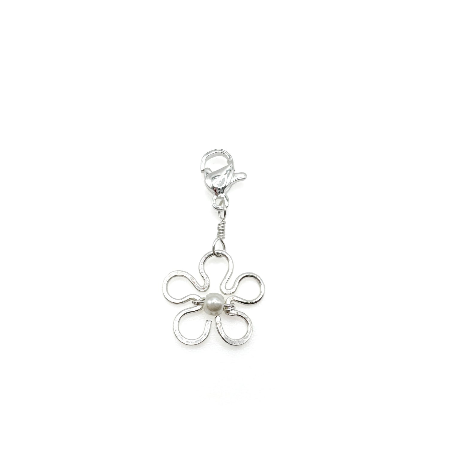 Silver flower-shaped charm on a white background