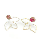 Gold flower jacket earrings with flat pink agate stone behind a gold swirl center