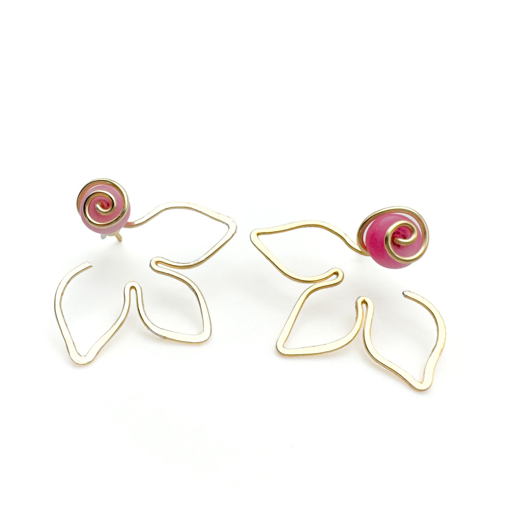 Gold flower jacket earrings with flat pink agate stone behind a gold swirl center