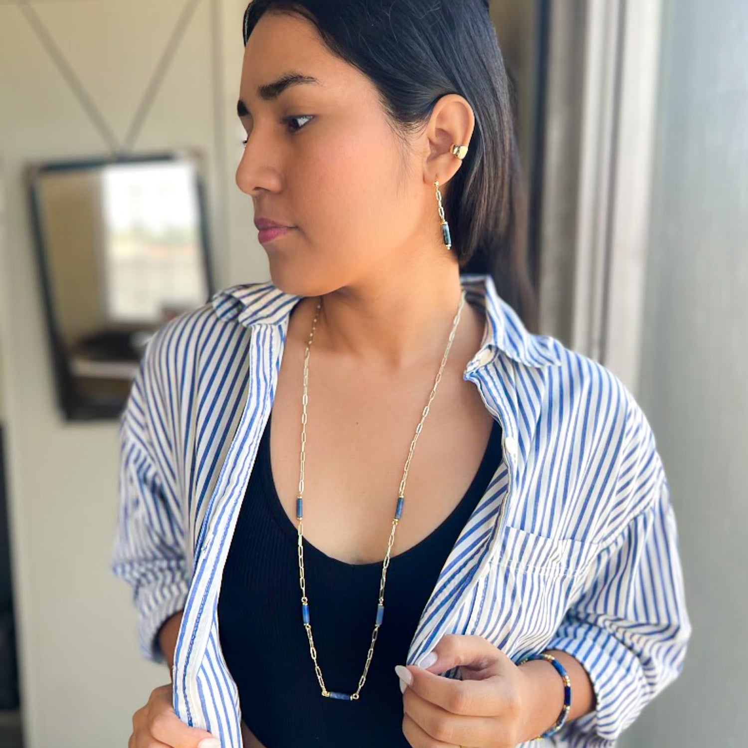 Woman wearing blue agate and gold paperclip chain jewelry