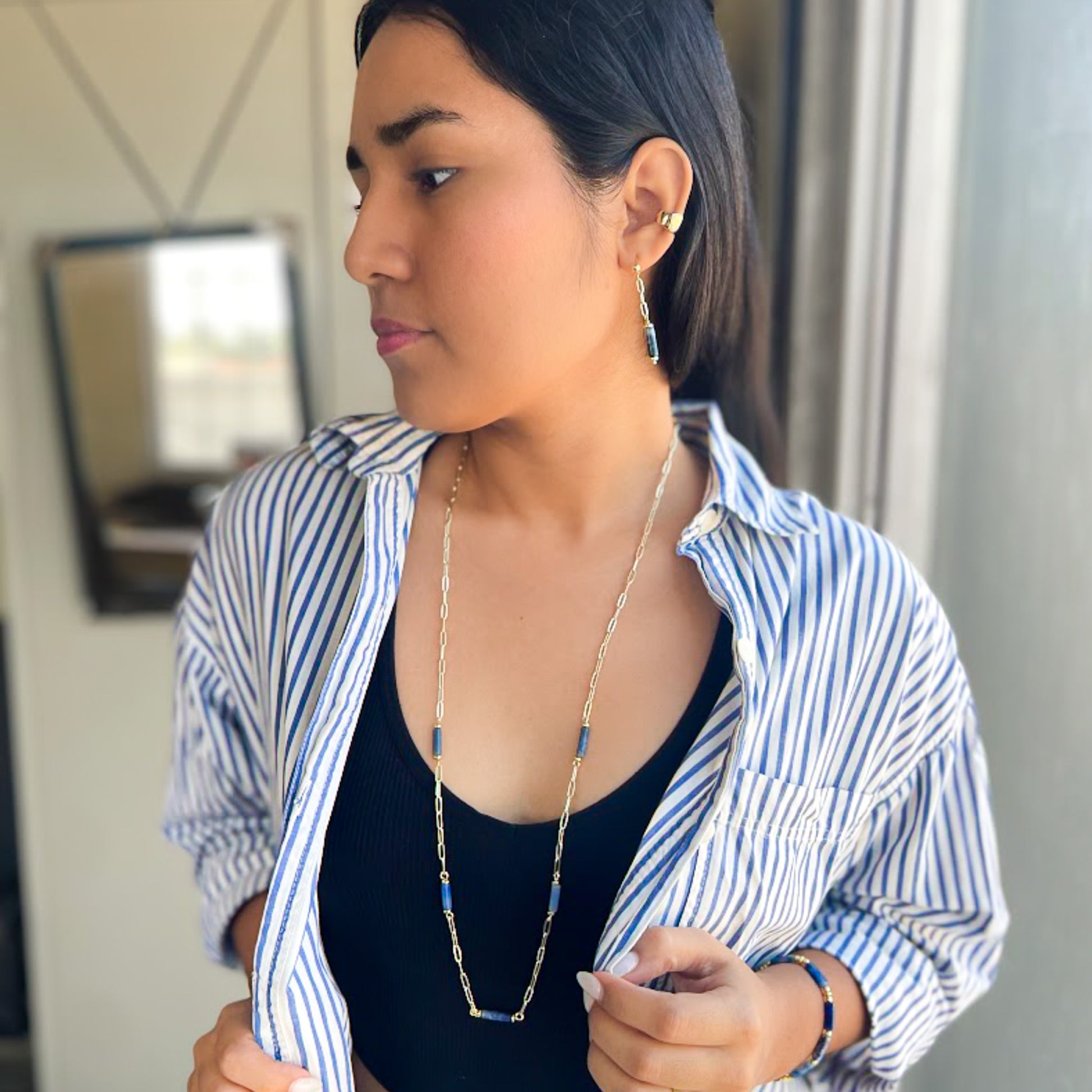 Woman wearing blue agate and gold paperclip chain jewelry