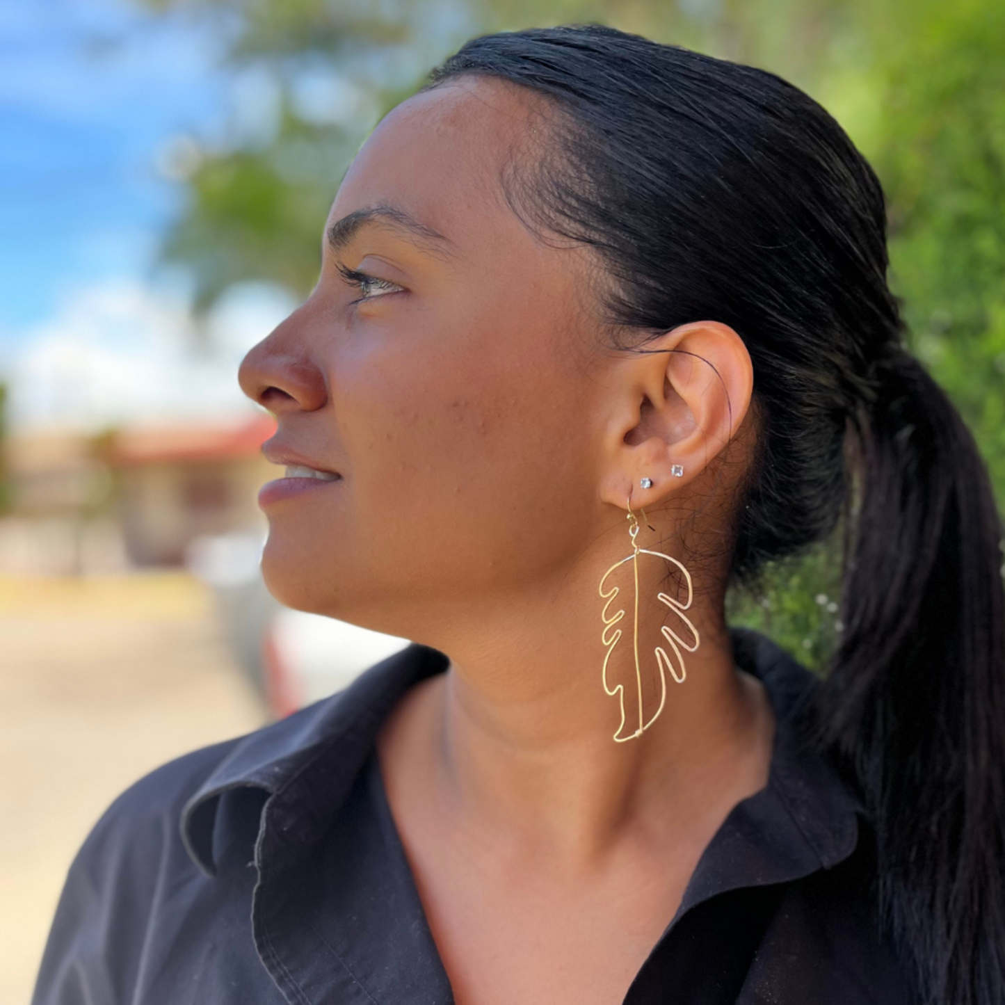 Gold feather earrings modeled