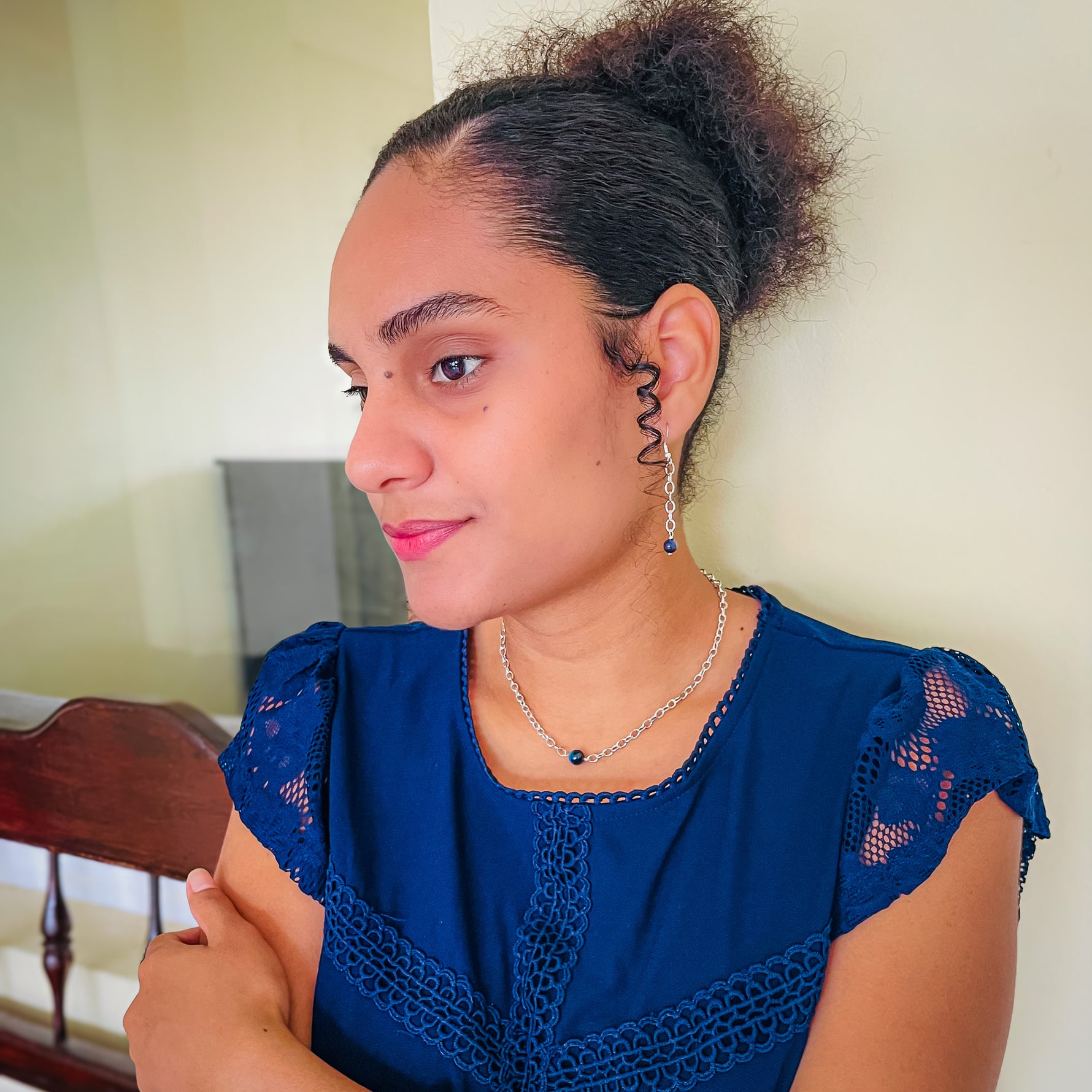Woman modeling silver chain dangle earrings and choker necklace with blue agate bead