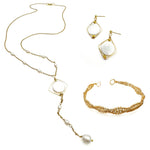 Gold and pearl jewelry set including isometric mother of pearl dangle earrings, intricate wire-wrapped gold cuff bracelet, and Y-shaped necklace with mother of pearl isometric pendant and pearl drop