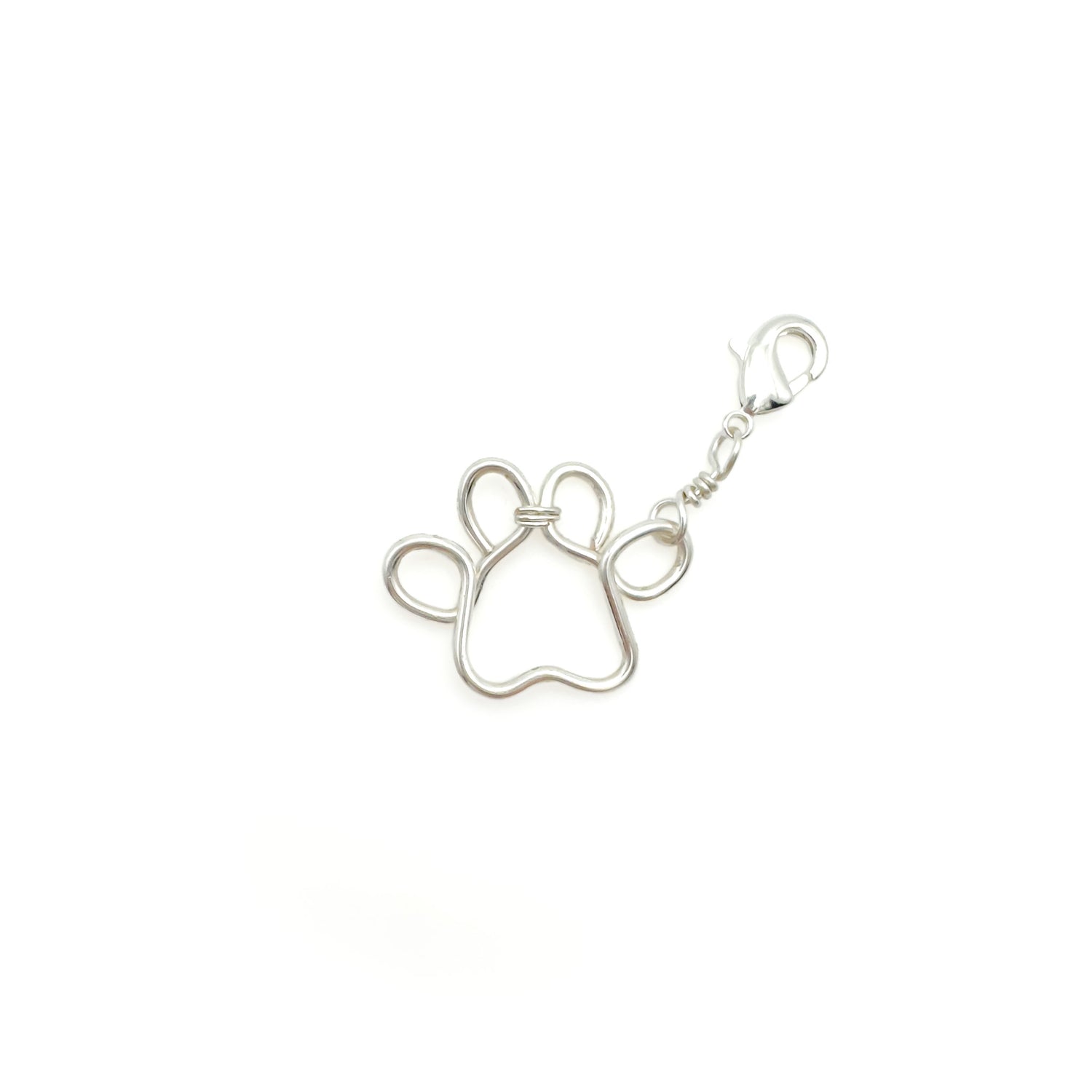 Silver paw print charm on a white background