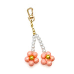 Peach blossom bag charm with pink, gold, and pearl beaded flowers hanging from a gold chain clasp