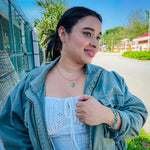 Woman modeling gold and green agate jewelry set with teardrop dangle earrings, beaded stretch bracelet, and green aventurine stone pendant necklace