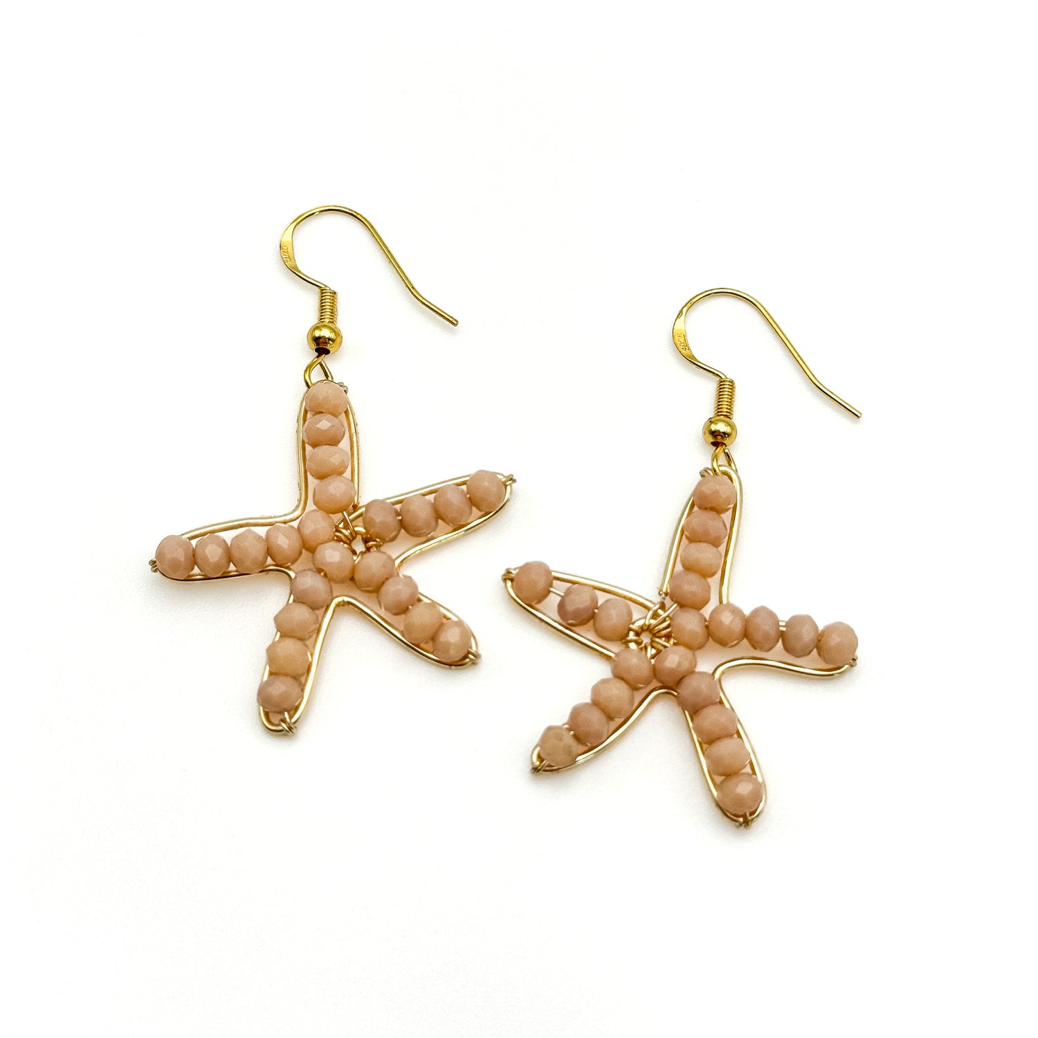 Gold starfish dangle earrings with peach crystal design