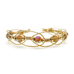 Intricate gold wire cuff bracelet with iridescent synthetic brown moonstone beads