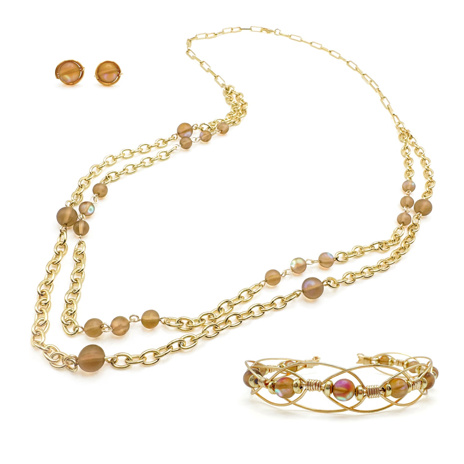 Iridescent synthetic brown moonstone and gold jewelry set including stud earrings, intricate wire cuff bracelet, and long, multi-strand chain and moonstone station necklace