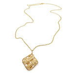 Long gold necklace with intricate, interwoven pendant