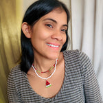 Woman modeling short, multi-strand beaded necklace including red, green, and black watermelon pattern strand and white strand with watermelon pendant